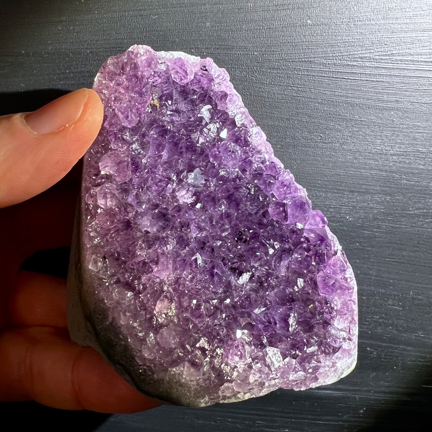 Uruguay Amethyst, polierte Kanten, stehen. Intensive lila Farbe. In der Hand. | Happy Minerals