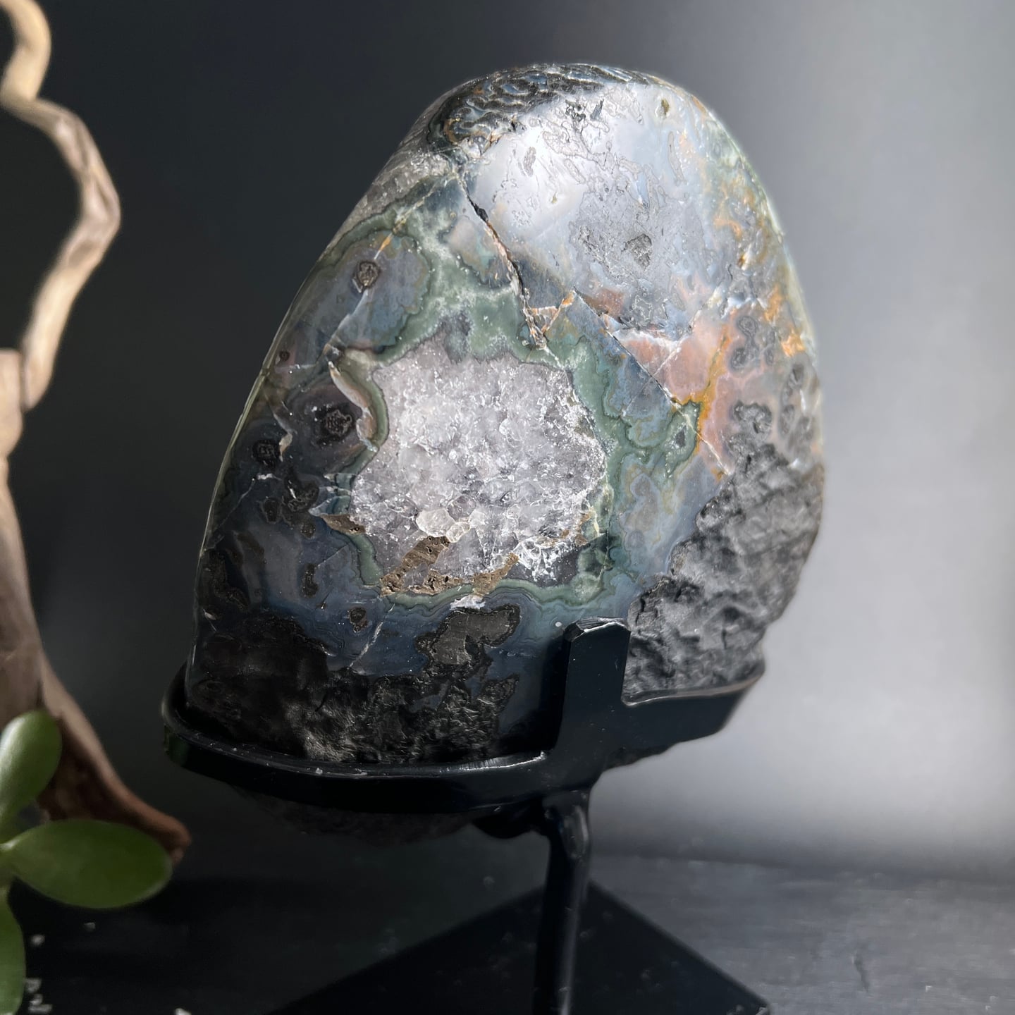 Polierte Achat Geode mit bunten Schichten in grün, blau und grau auf schwarzem Ständer | Happy Minerals