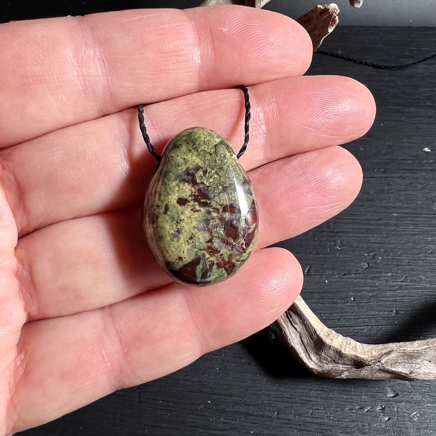 Drachenblut Jaspis Anhaenger in der Hand zur Groessenwirkung | Happy Minerals