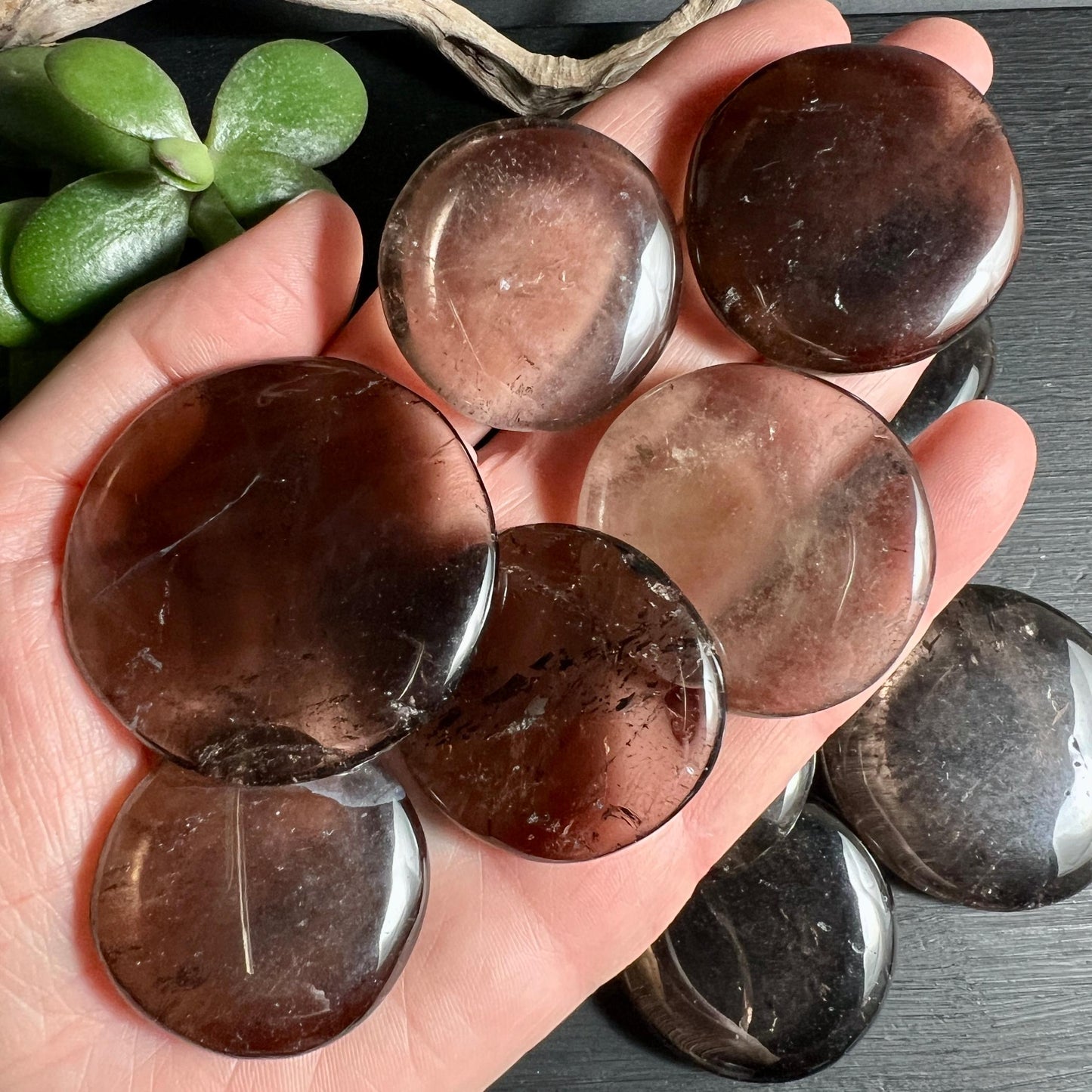 Mehrere Rauchquarz Taschensteine in Hand zeigen Farbvariationen