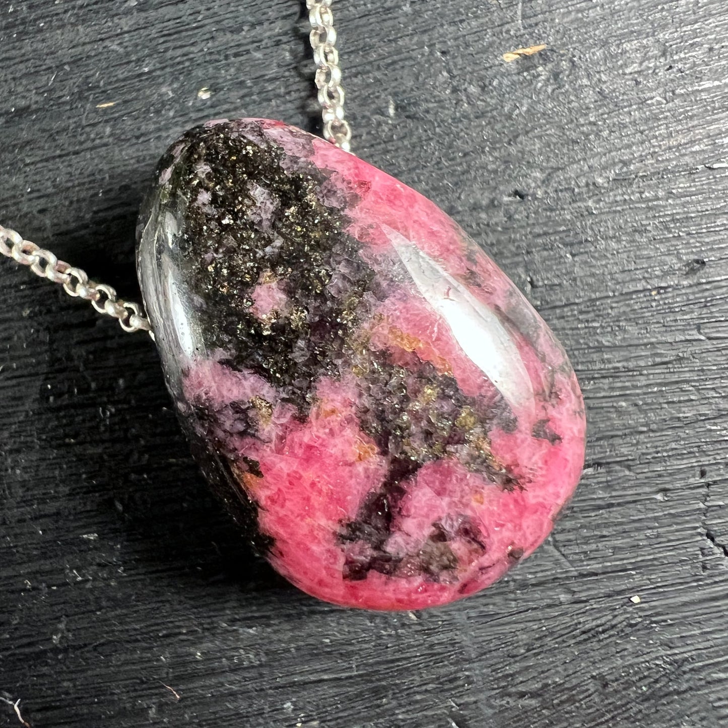 Rhodonit Unikat Nahaufnahme | pinke & schwarze Muster | seitliche Ansicht | Silberkette | Happy Minerals