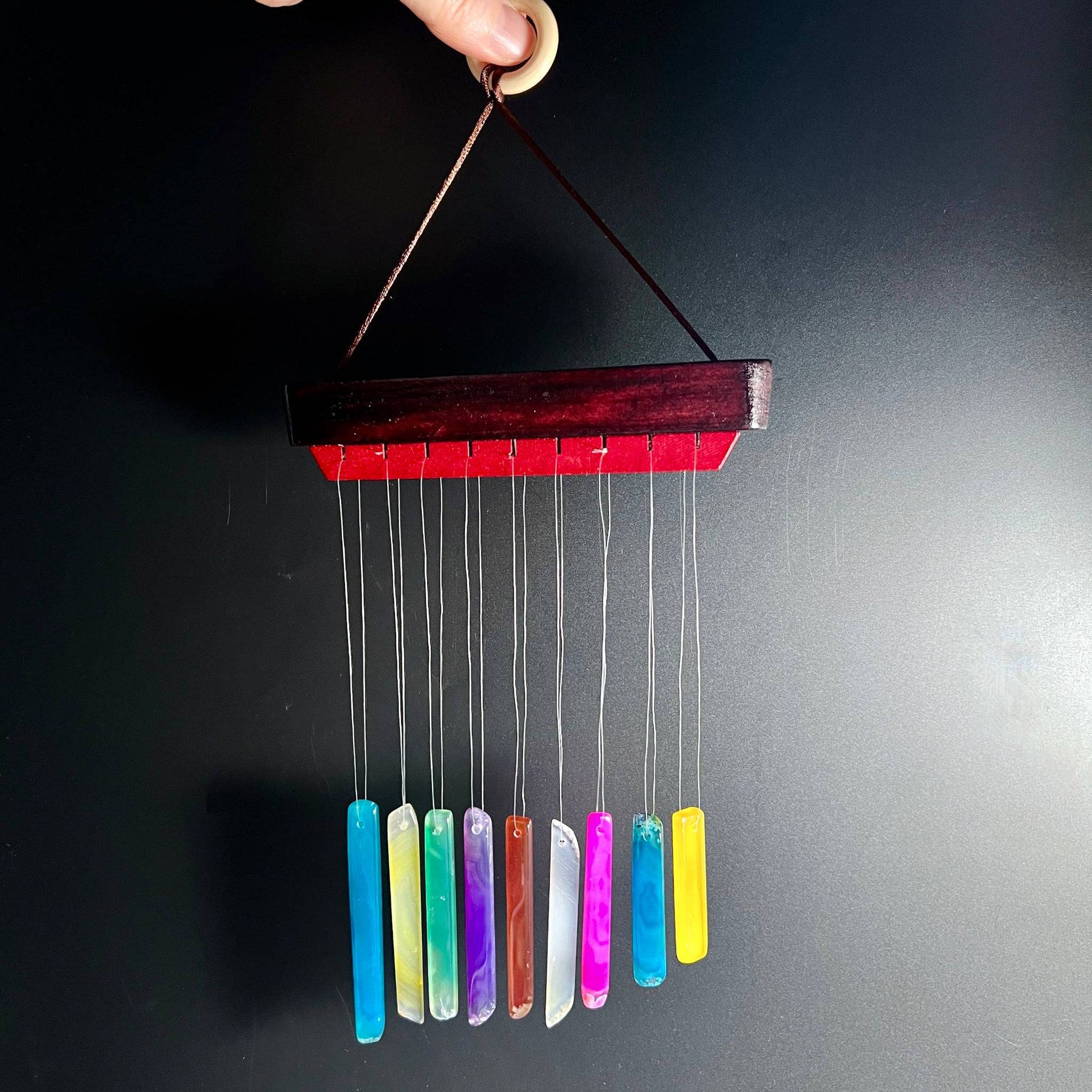 Achat Klangspiel in der Hand gehalten zeigt kompakte Größe mit bunten Klangstäben | Happy Minerals