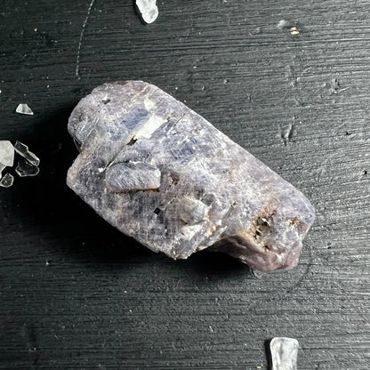 Rosa-blauer Saphir Rohstein auf dunklem Holz | schimmernde Kristallflächen | Happy Minerals