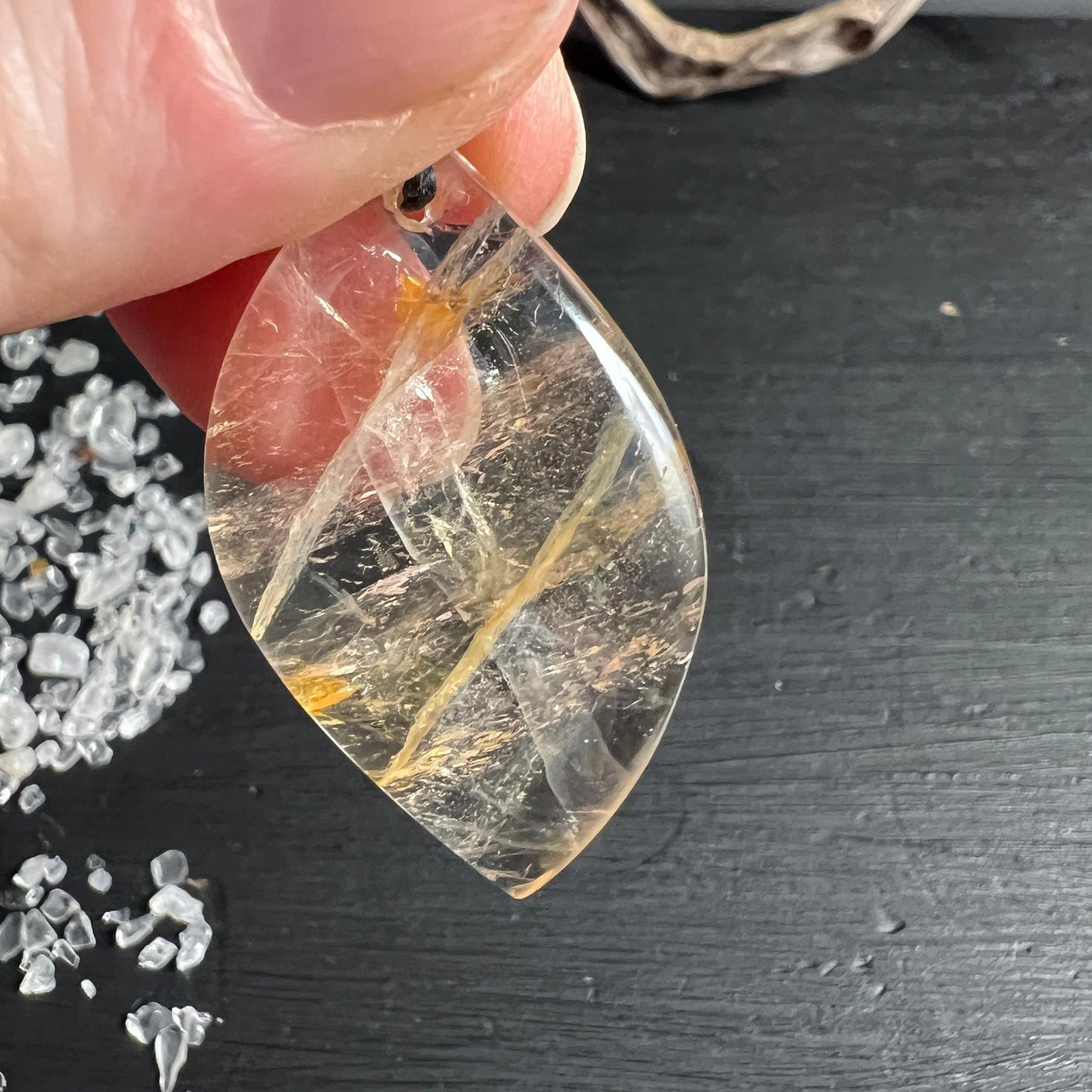 Golden Healer Quarz Anhänger in der Hand mit warmem Limonit-Schimmer | Happy Minerals