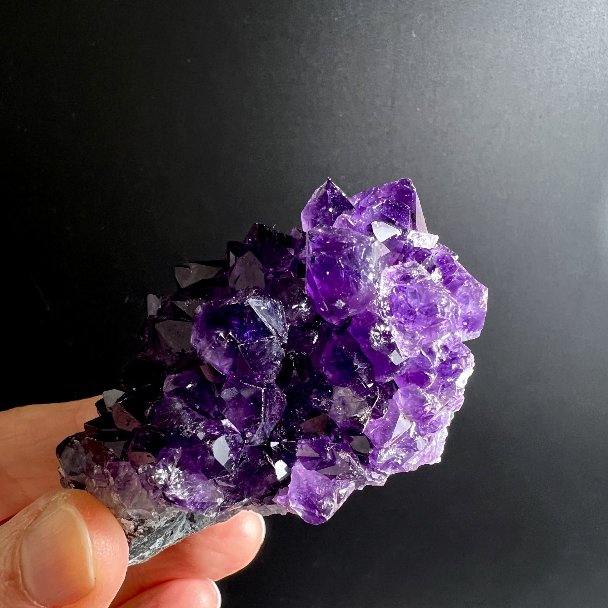 Hand hält Amethyst Igel mit kompakter Form und Calcit-Einschluss, Clusterstruktur sichtbar | Happy Minerals