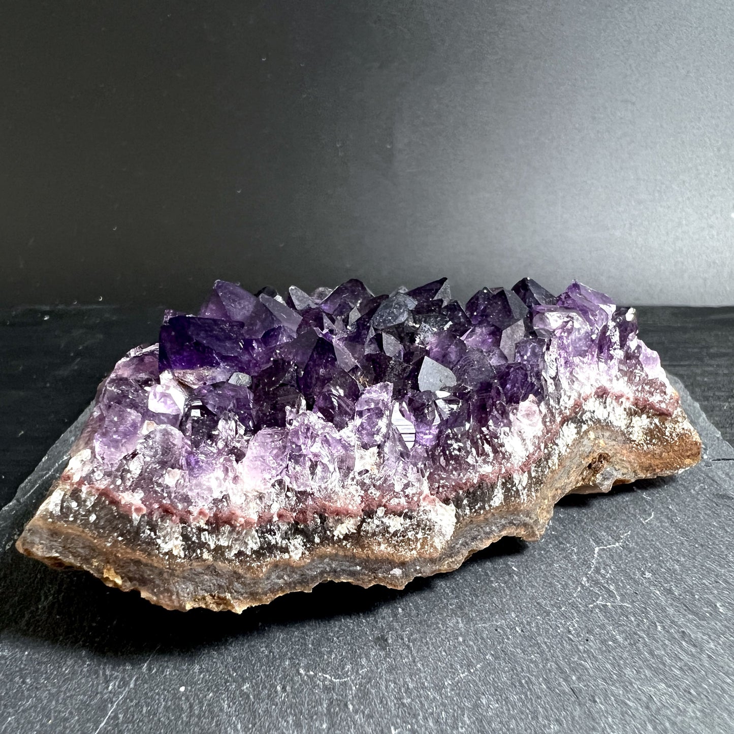 Hand hält klassischen Amethyst mit tiefem Violett | Happy Minerals