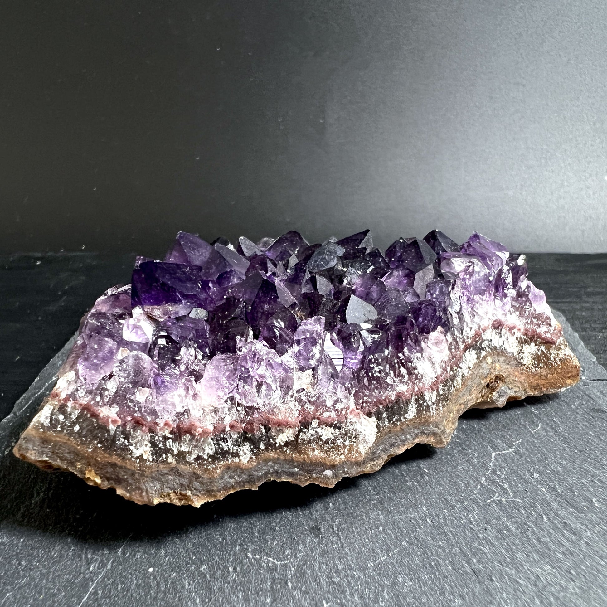 Hand hält klassischen Amethyst mit tiefem Violett | Happy Minerals