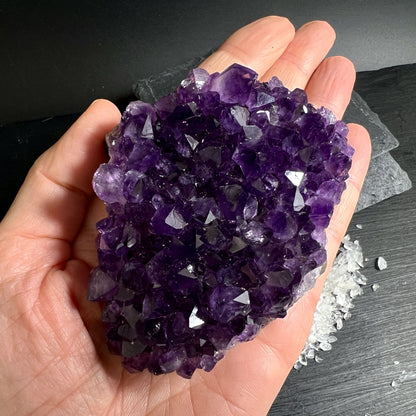 Handgehaltenes Amethyststück aus Uruguay mit intensiver Farbe und Kristallstruktur | Happy Minerals