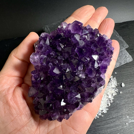 Handgehaltenes Amethyststück aus Uruguay mit intensiver Farbe und Kristallstruktur | Happy Minerals