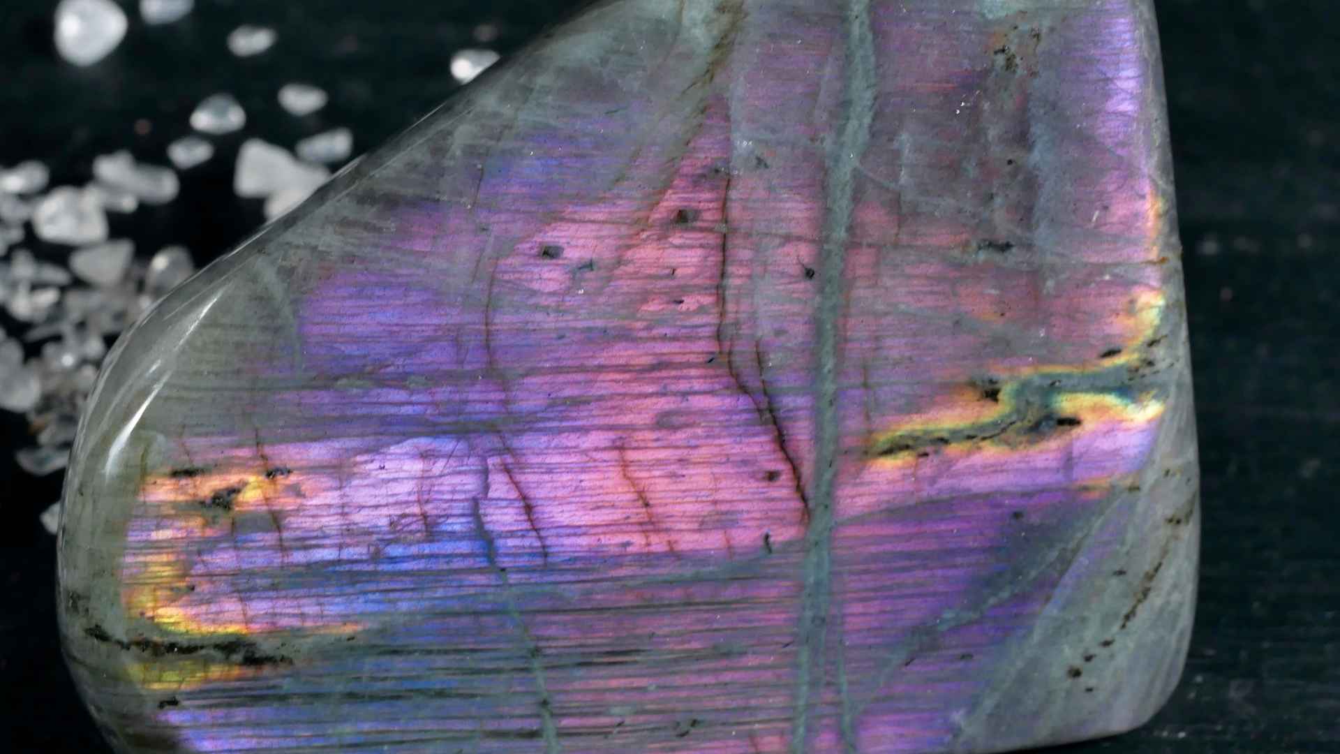 Lila Labradorit auf dunklem Holz. Happy Minerals Shop Banner, der Shop für echte Mineralien und edlen Schmuck.