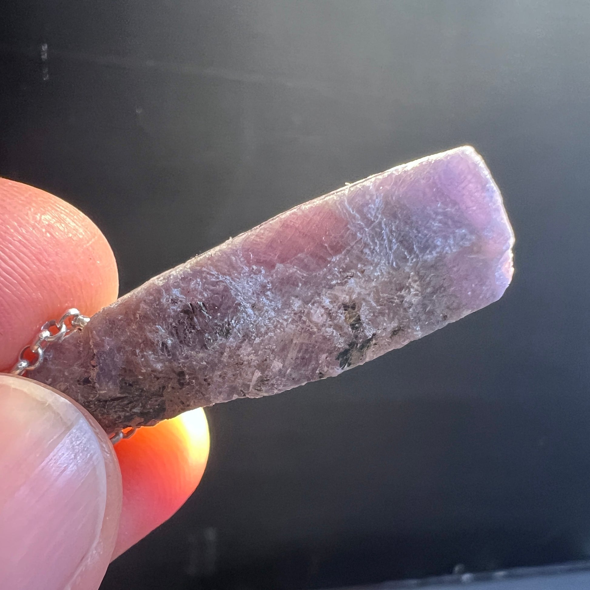 Lila-Blauer Saphir Anhänger&nbsp; – ein echtes Naturwunder aus Madagaskar! Der lila-blaue Saphir Kristall, ca. 30x10mm, im Licht. | Happy Minerals
