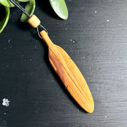 Handgeschnitzter Palo Santo Holz Anhänger Feder | warmgoldene Maserung auf schwarzem Grund | Happy Minerals