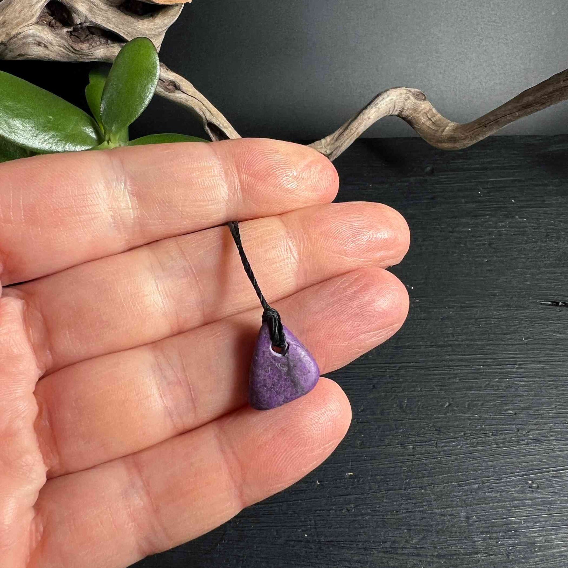 Mini Sugilith Anhänger mit schwarzem Band - in der Hand - Happy Minerals