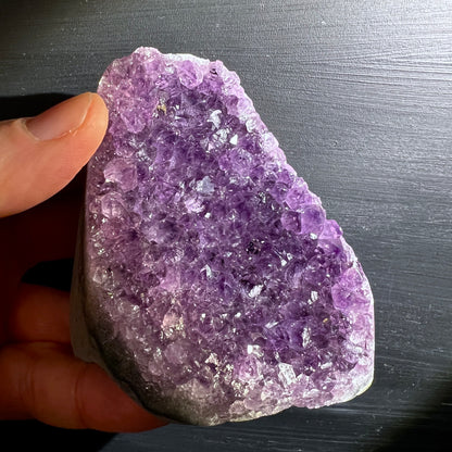 Uruguay Amethyst, polierte Kanten, stehen. Intensive lila Farbe. In der Hand. | Happy Minerals