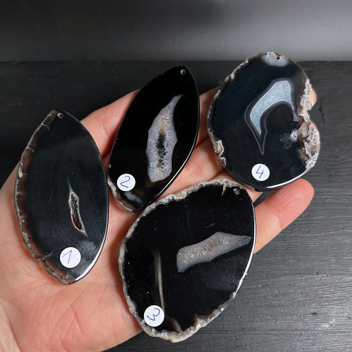 Vier Achat-Anhänger | in Hand präsentiert | Vergleich Größe & Farbe | Happy Minerals