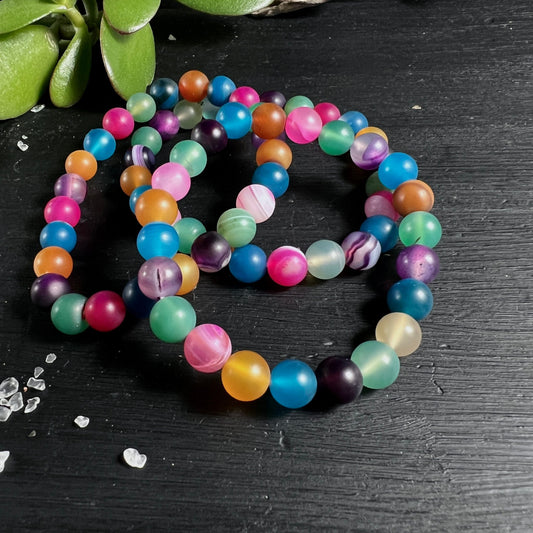 Bunte Achat Perlen | gefärbt | Brasilien | rund | mehrfarbig | Kette auf dunklem Holz | Happy Minerals