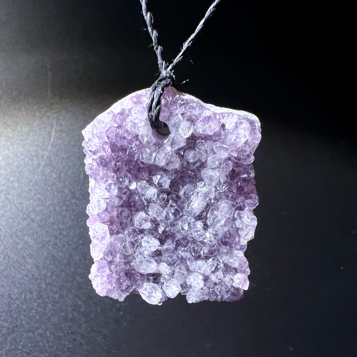 Amethyst | Anhänger | hängend an Kordel | dunkler Hintergrund | mystisches Lila | Happy Minerals