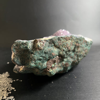 Rohstein mit moosgruener Matrix, rostbraunen Flecken und violetten Amethystkristallen an der Oberkante | Happy Minerals