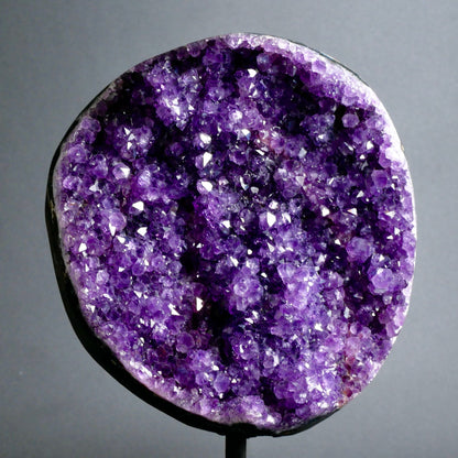 Runde Amethyst Druse mit dicht besetzten violetten Kristallspitzen, glitzernd, auf schwarzem Metallständer | Happy Minerals