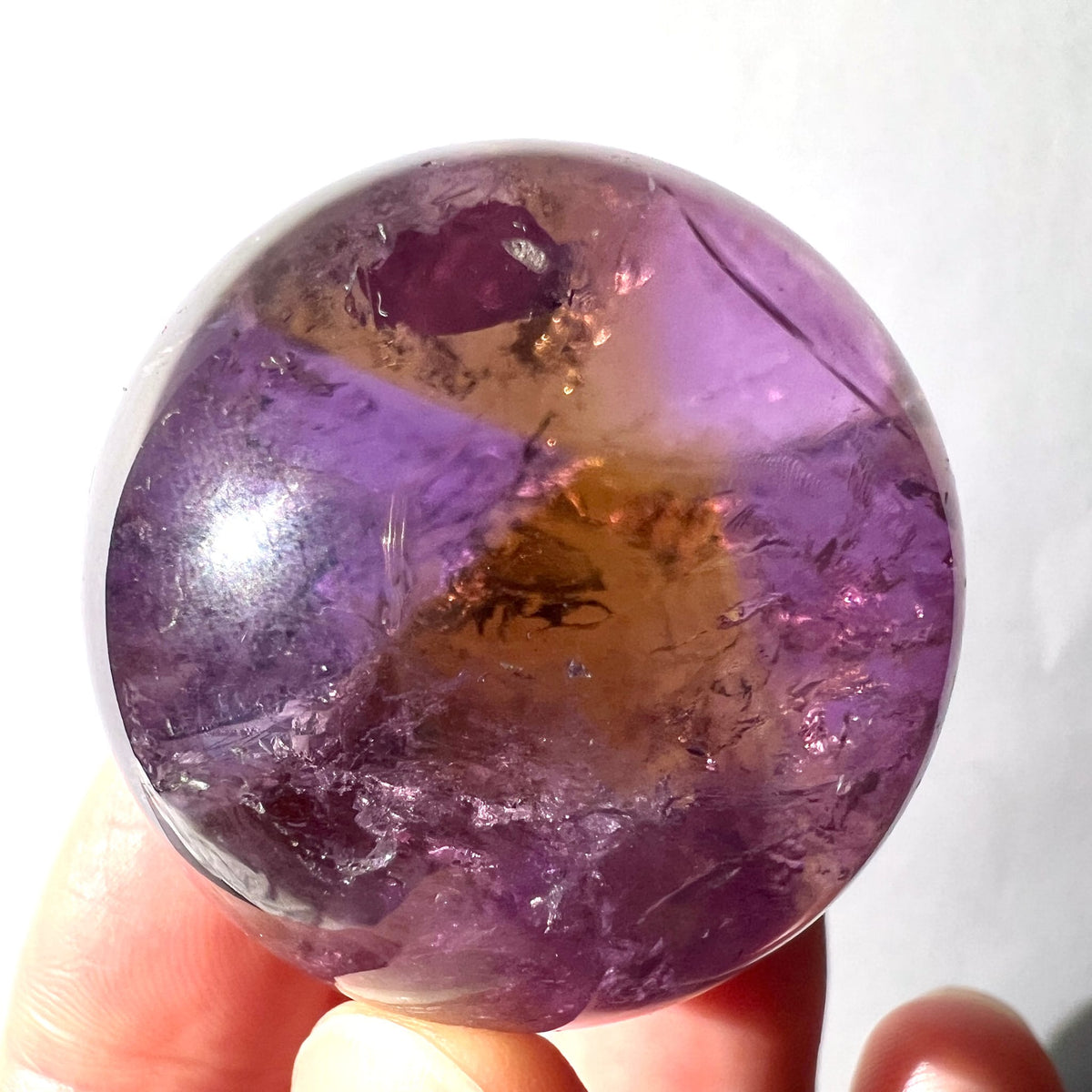 Ametrin Kugel poliert mit lila und goldbraunen Zonen, dunklen Einschluessen und Glanz | Happy Minerals