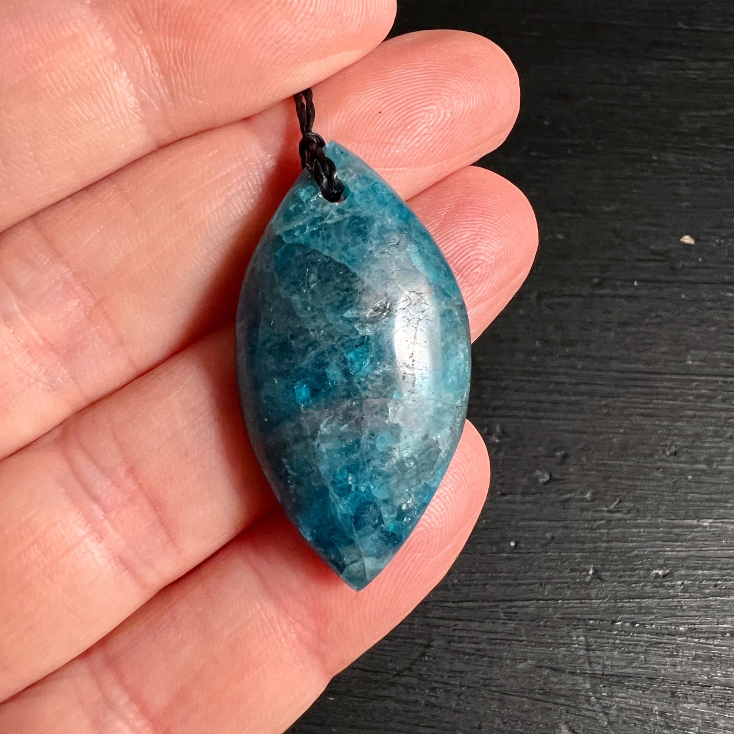 Blauer Apatit Anhänger in Hand zeigt Groesse und Farbtiefe