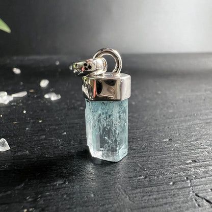 Aquamarin Anhänger: eisblau-transparenter Rohkristall, Stabform, silbrige Einschlüsse, Silberfassung | Happy Minerals