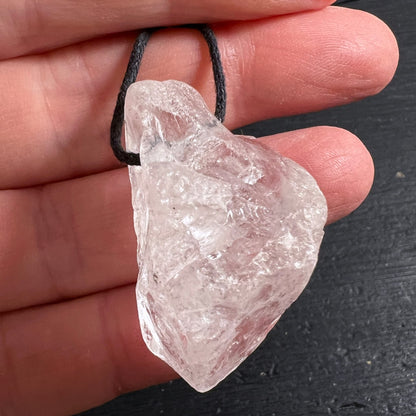 Roher Bergkristall Anhaenger transparent-milchig mit facettierten Bruchkanten und Glanz, an Hand gehalten | Happy Minerals