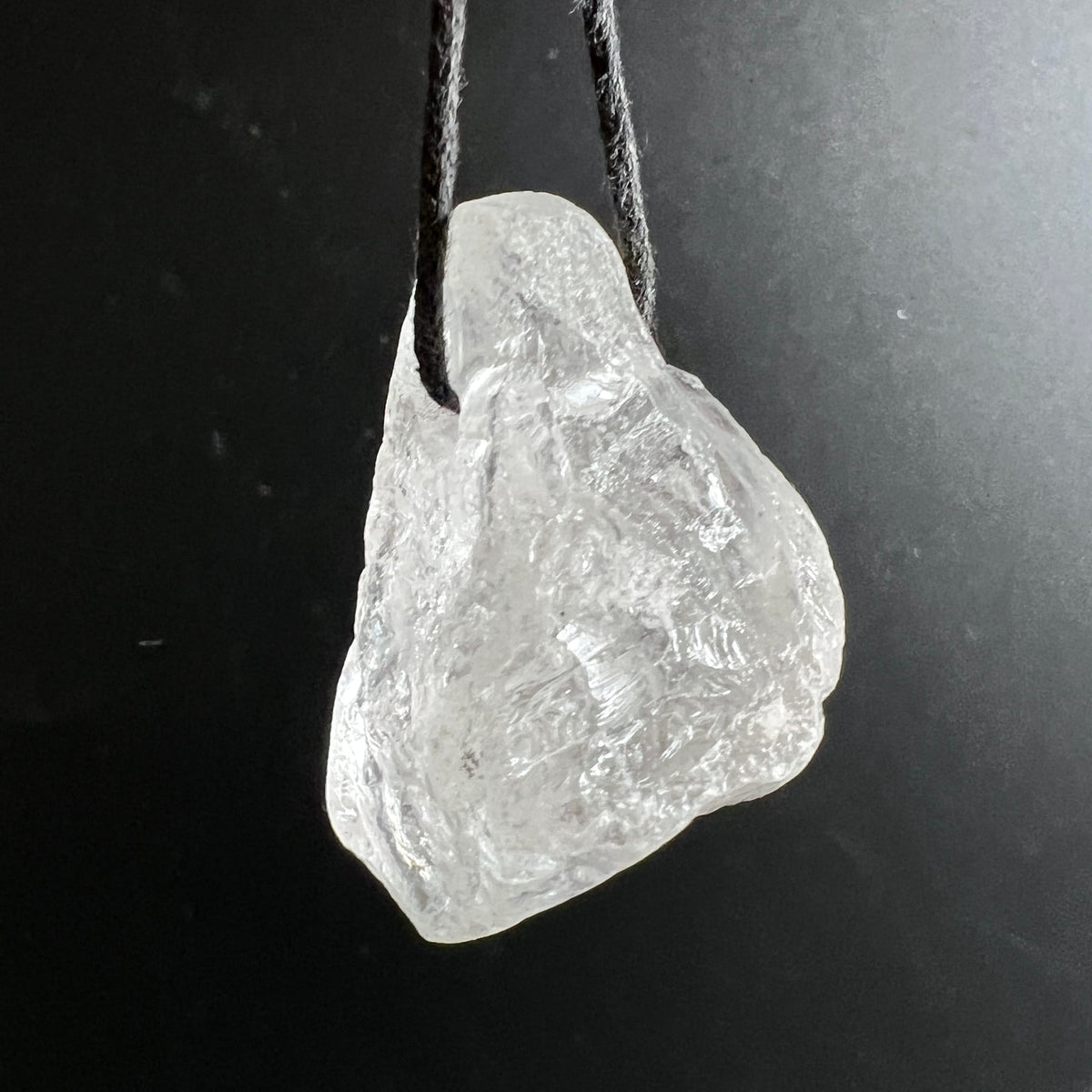 Roher Bergkristall Anhaenger, transparent-weiss mit facettierten Bruchkanten und Glanz, an schwarzer Schnur | Happy Minerals