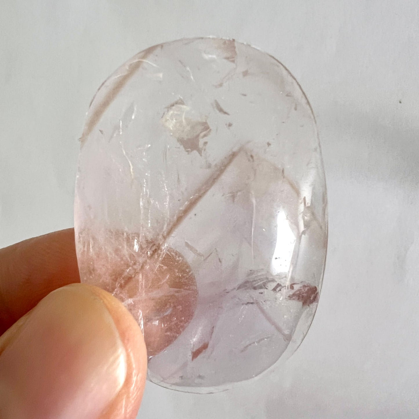 Bergkristall Handschmeichler, oval-poliert, glasklar mit diagonalen Rissen, braunen Schlieren und Fluorit-Einschlüssen | Happy Minerals
