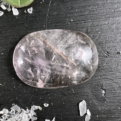 Bergkristall Handschmeichler oval poliert, transparent mit rosé Schimmer, rötlich-brauner Nadel-Einschluss, seidige Schlieren | Happy Minerals