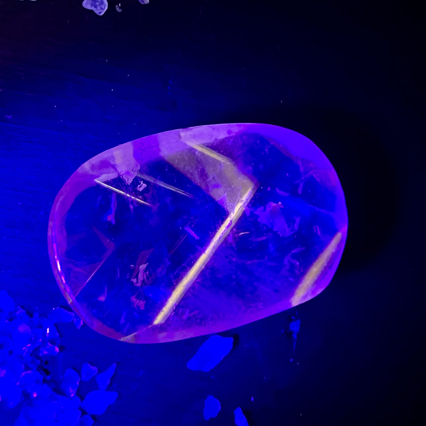 Bergkristall Handschmeichler oval-poliert, rosa-violett fluoreszierend, mit gelbem Cleavage-Einschluss diagonal | Happy Minerals