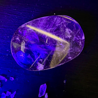 Bergkristall Handschmeichler oval-poliert, transparent mit gelb-grünem Fluorit-Band und violetter UV-Fluoreszenz | Happy Minerals