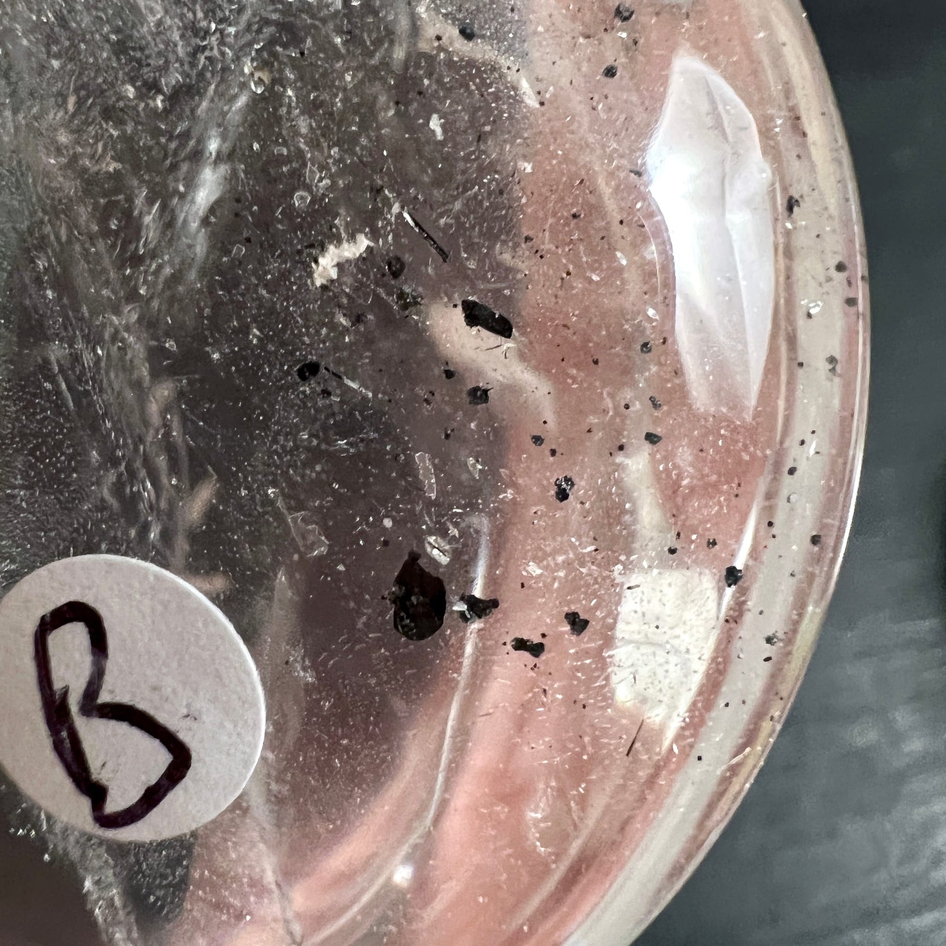 Bergkristall Handschmeichler Variante B | Detailaufnahme | schwarze Einschlüsse | rosa Töne | Happy Minerals