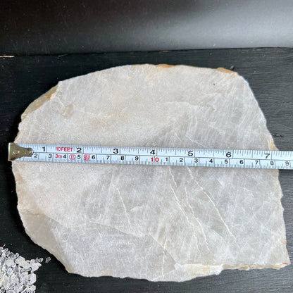 Rohe Bergkristall Platte cremig-weiss mit feinen Rissen, flache unregelmaessige Form, Massband zeigt Groesse | Happy Minerals