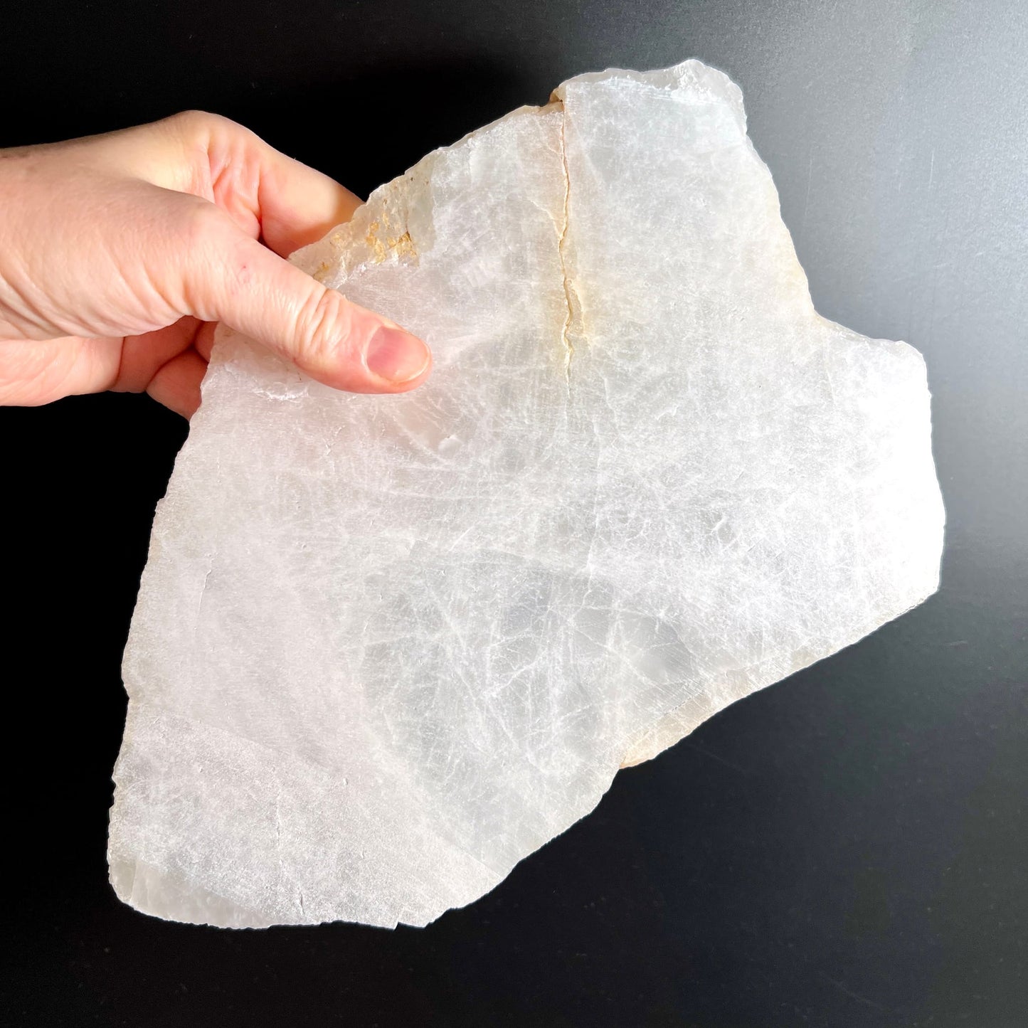 Bergkristall Platte milchig-transparent mit feinem Riss und rauen Bruchkanten, in Hand gehalten | Happy Minerals