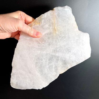 Bergkristall Platte milchig-transparent mit feinem Riss und rauen Bruchkanten, in Hand gehalten | Happy Minerals