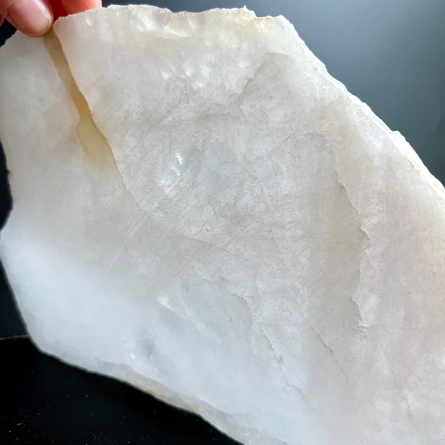 Bergkristall Platte milchig-weiss mit grauen Wolken, rohe gezackte Kante, in Hand gehalten | Happy Minerals