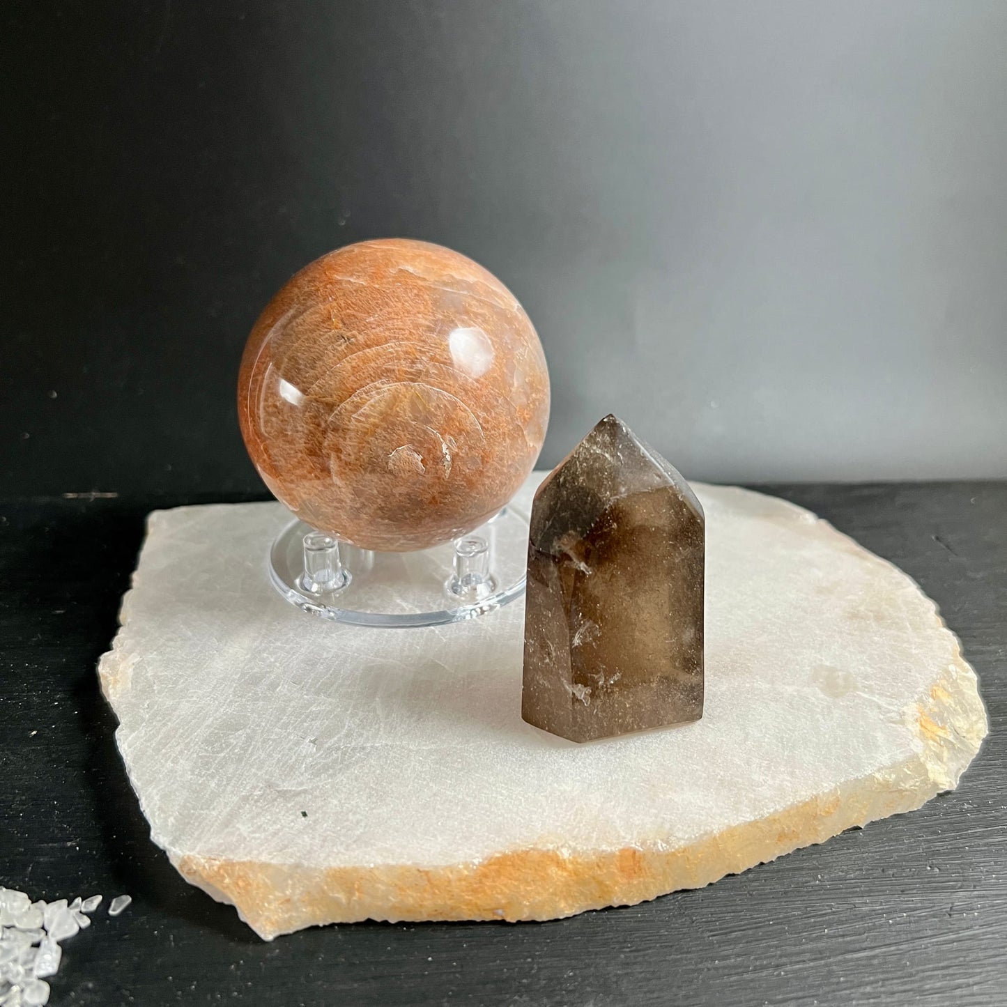 Bergkristall Platte cremig-weiss mit goldbraunem Rand, darauf orangene Sonnenstein Kugel und Rauchquarz Spitze | Happy Minerals