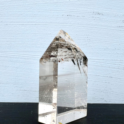 Polierte Quarzspitze | heller Hintergrund | andere Seite | leichte Rauchfärbung | Unikat | Happy Minerals