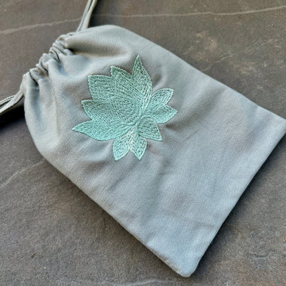 Grauer Bio-Stoffbeutel mit mintgrüner Lotus-Stickerei, Kordelzug, glatte Twill-Textur, 19x13 cm | Happy Minerals