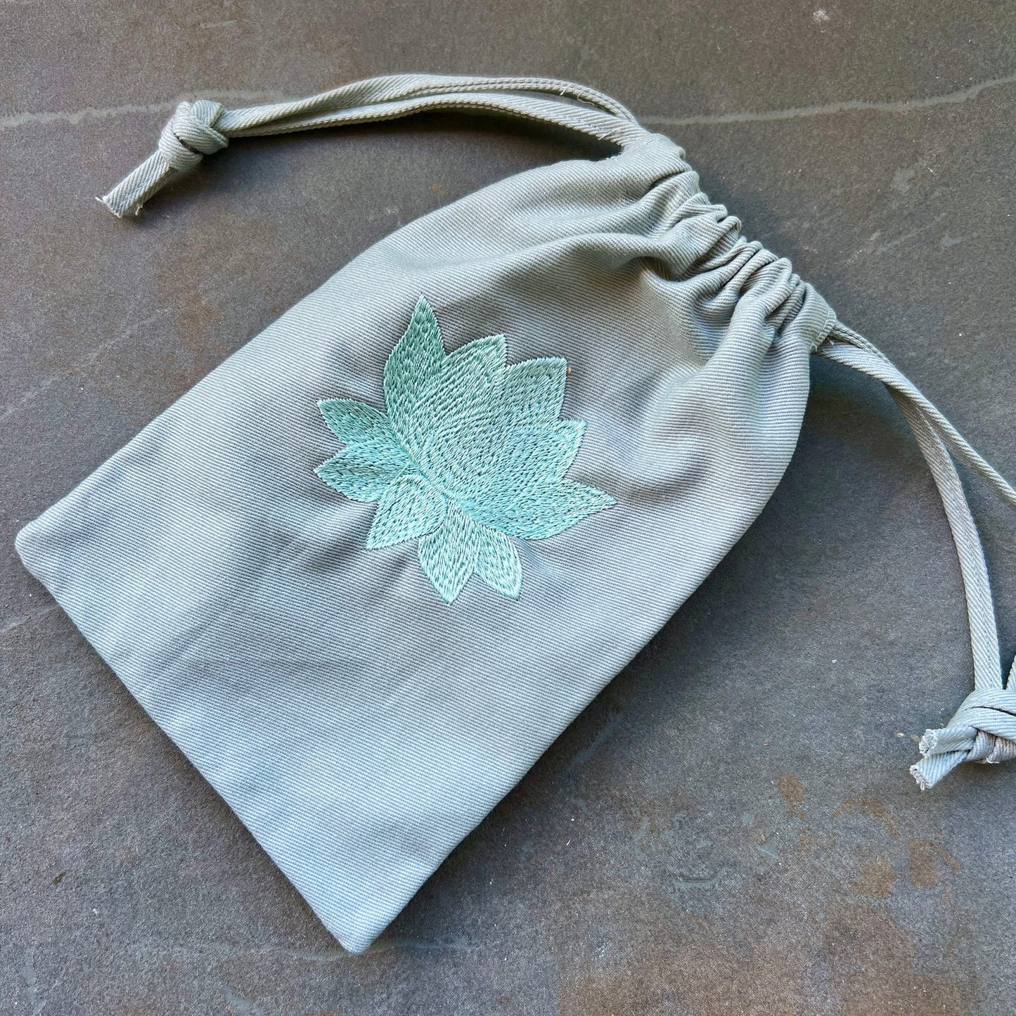Mintgrüner Bio-Stoffbeutel mit türkis gestickter Lotusblüte, Kordelzug, weicher Twill-Stoff | Happy Minerals