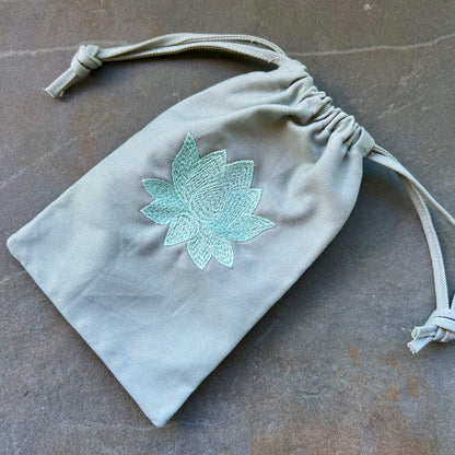 Mintgrüner Bio-Stoffbeutel mit türkis gestickter Lotusblüte, Kordelzug, weicher Twill-Stoff | Happy Minerals