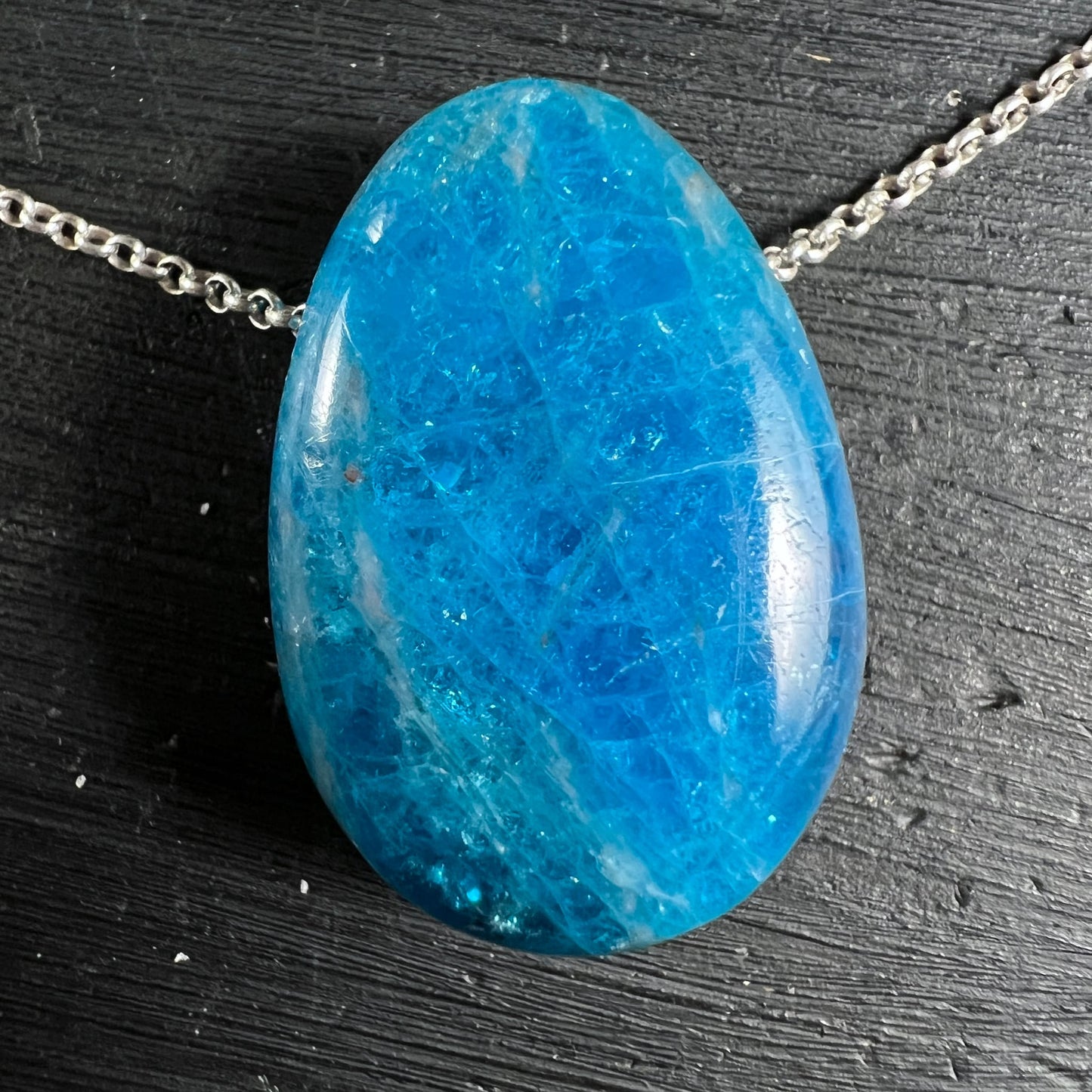 Blauer Apatit Anhänger | liegend auf Holz | Silberkette | aquamarines Schimmern | Happy Minerals