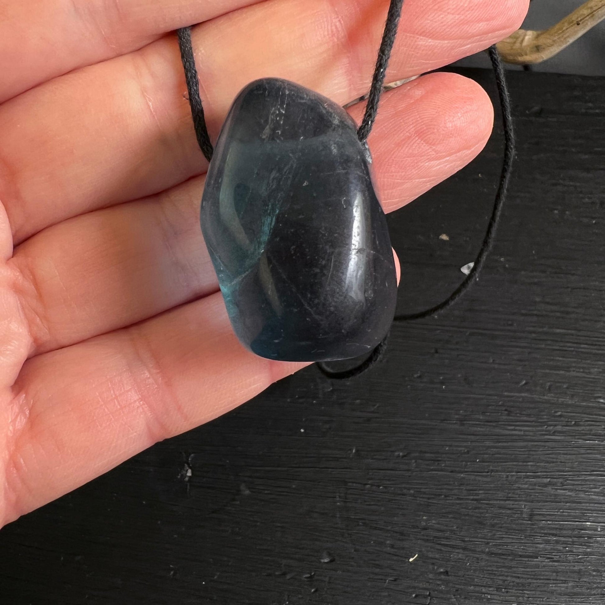 Blauer Fluoritanhänger in der Hand