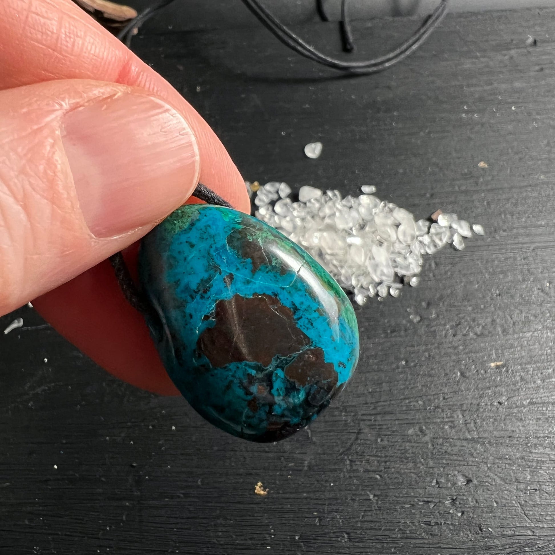 Chrysokoll Peru | Rückseite | rotbraune Einschlüsse | türkis-grün | schwarzes Band | Hand | Happy Minerals