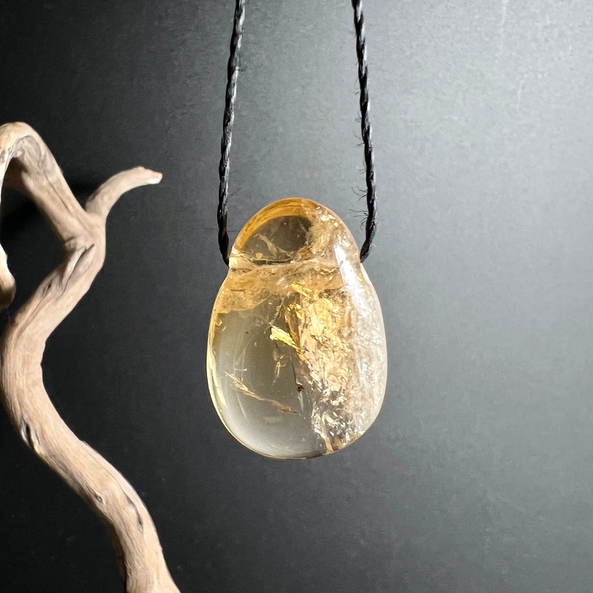 Citrin Tropfen | hängende Perle | braunes Holz | Licht durchscheinend | Happy Minerals | warme Farben