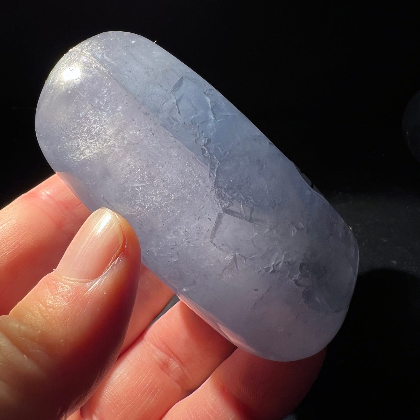 Celestit Handschmeichler Variante E | zarte Lavendeltöne | glatte Oberfläche | Gegenlicht | Happy Minerals