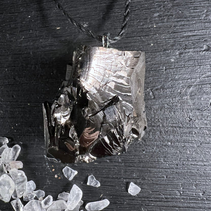 Edelschungit Anhänger | auf schwarzem Untergrund | mit Bergkristall-Splittern | metallischer Schimmer | Happy Minerals
