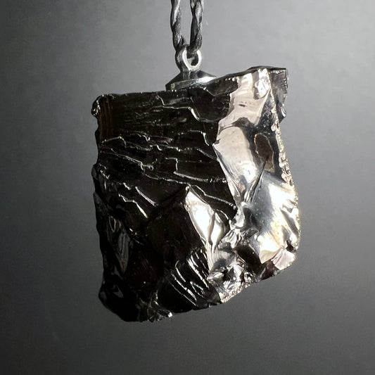 Edelschungit Anhänger | seitliche Ansicht | silbrig schimmernde Spaltflächen | tiefschwarz | Happy Minerals