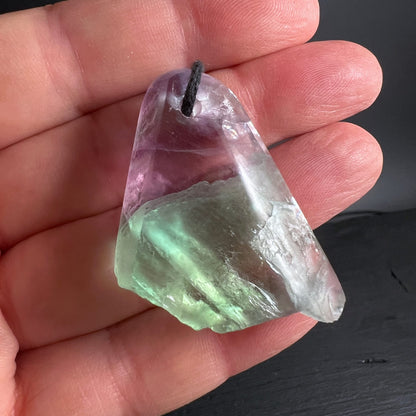 Fluorit Anhänger mit lila-grünem Farbverlauf, teilweise poliert, rohe Unterseite, Bohrung mit schwarzer Kordel | Happy Minerals